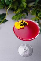 Elegant pink cocktail with edible flower garnish photo