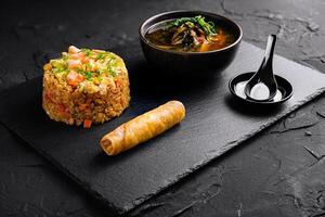 Gourmet asian fusion meal on slate background photo