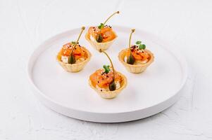 Gourmet smoked salmon tartlets on white plate photo