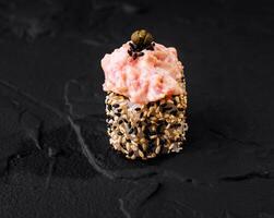 Gourmet spicy tuna roll on black slate photo