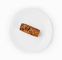 Single granola bar on white plate photo