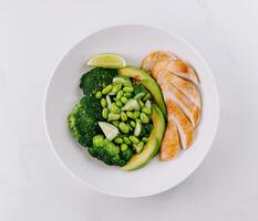 Healthy grilled chicken plate with vegetables and lime photo