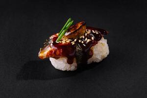 Gourmet unagi nigiri sushi on dark backdrop photo