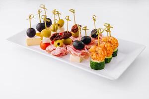 Gourmet appetizer selection on a white platter against a clean backdrop photo