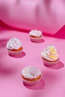 Festive cupcakes on pink background photo