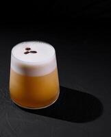 Classic whiskey sour cocktail with frothy top, served on a dark, moody background photo