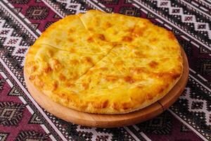 Traditional georgian cheese bread khachapuri on wooden board photo