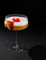 Elegant cocktail with floral garnish on dark background photo