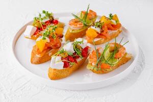 Elegant platter of assorted bruschetta with fresh toppings on a white background photo