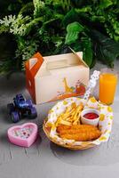 Kids meal with toy and juice on table photo