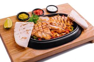 Sizzling chicken fajitas platter with condiments photo