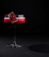 Elegant cocktail with artistic garnish on black background photo