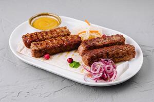 Grilled kebabs platter with sauces and salad photo