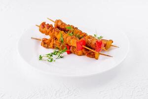 Juicy grilled chicken skewers on white plate photo