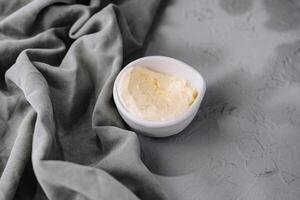 Fresh creamy butter in white bowl on linen photo