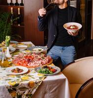 Man enjoying a feast of italian dishes photo