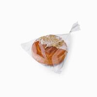 Fresh bread in plastic bag isolated photo