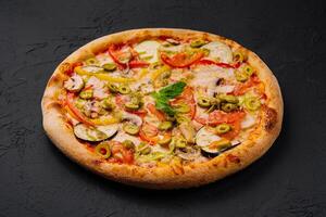 Freshly baked vegetable pizza on black background photo