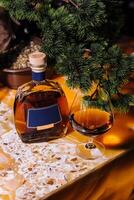 Festive brandy and glass by christmas tree photo