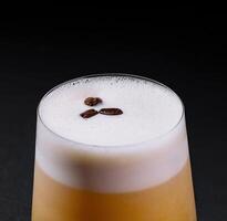 Classic whiskey sour cocktail with frothy top, served on a dark, moody background photo