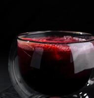 Elegant glass of red tea on dark background photo