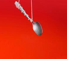 Levitating spoon on red background photo