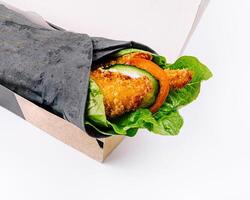 Fresh veggie wrap in takeout box on white background photo