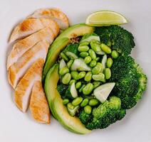 Healthy grilled chicken plate with vegetables and lime photo