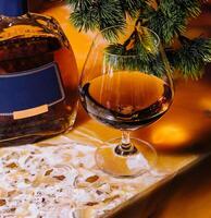 Festive brandy and glass by christmas tree photo