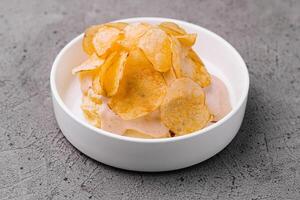 Bowl of crispy golden potato chips photo