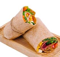 Fresh chicken wrap sandwich on wooden board photo