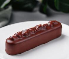 Elegant chocolate bar dessert on white plate photo