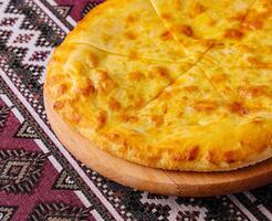 Traditional georgian cheese bread khachapuri on wooden board photo