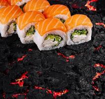Sushi roll on textured black surface photo
