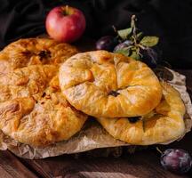 Rustic homemade apple pies on wooden table photo