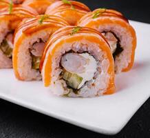 Delicious salmon sushi roll on white plate photo