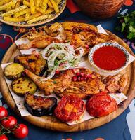 Traditional grilled chicken platter with vegetables and spices photo