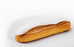 Delicious classic eclair on white plate photo