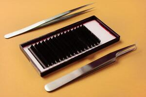 Professional eyelash extension tools on yellow background photo