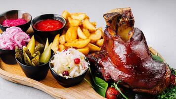 Gourmet roasted pork knuckle platter with sides photo