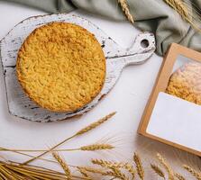 Homemade apple pie on rustic cutting board with wheat decor photo