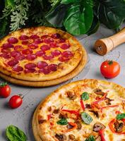 Delicious pepperoni and veggie pizzas on wooden boards photo