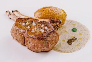 Gourmet lamb chop on elegant white plate photo