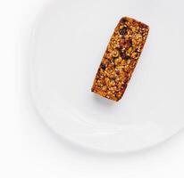 Single granola bar on white plate photo