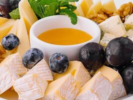 Gourmet cheese platter with honey and fruits photo