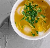 Homemade chicken noodle soup in bowl photo