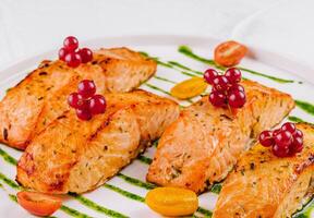 Grilled salmon fillets with berries and pesto sauce photo