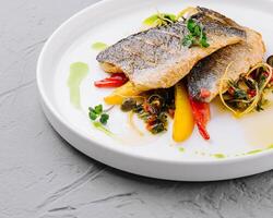 Gourmet pan-seared fish with vegetable garnish photo