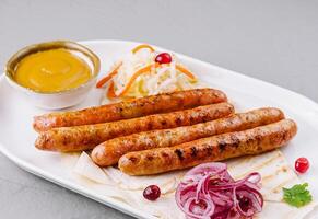 Grilled sausages with sauces and salad on plate photo