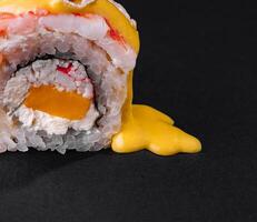 gastrónomo Sushi rodar con mango salsa en negro antecedentes foto